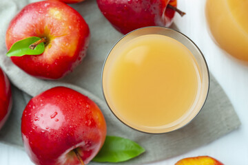 Refreshing apple juice in glass and fruits on white wooden table, flat lay