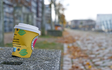 Naklejka premium Yellow Coffee Cup on Stone Ledge in Autumn