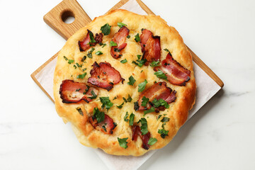 Delicious focaccia bread with bacon and parsley on white table, top view