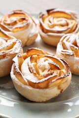 Freshly baked apple roses on plate, closeup