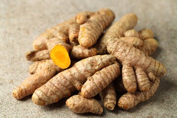 Pile of tumeric rhizomes on grey table, closeup