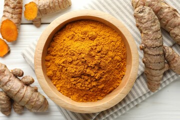 Aromatic turmeric powder and fresh roots on white wooden table, flat lay