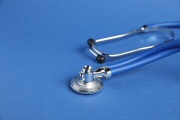 Stethoscope on blue background, closeup. Space for text