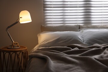 Glowing night lamp on bedside table indoors