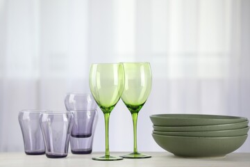 Empty clean glasses and bowls on table indoors
