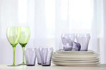 Empty clean glasses and plates on table indoors
