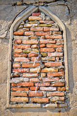 Dettaglio di una  finestra in stile gotico murata con dei mattoni a Venezia