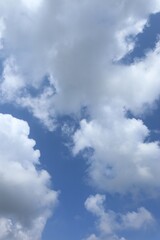 Serene blue sky adorned with puffy white clouds on a tranquil afternoon