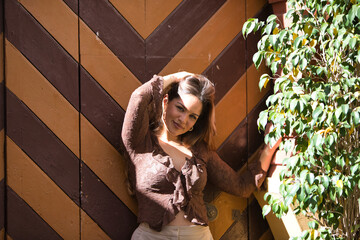 Blonde, young and beautiful woman receives the morning sun rays on her face. The woman has a brown...