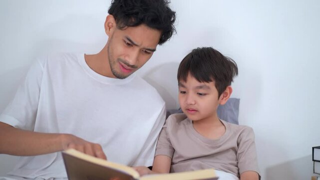 Asian man let his son learn about the holy koran.