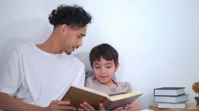 Asian man let his son learn about the holy koran.