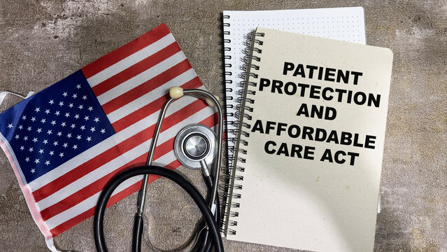 Concept of Patient Protection and Affordable Care Act write on book and Flag of the United States isolated on Wooden Table.