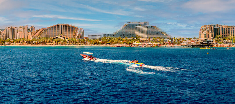 Water sport activities and resting on the Red Sea. Panoramic view on central public beach of Eilat – famous tourist resort city in Israel. My own photo. Traditional digital enhancement tools were used