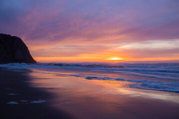 Scenic Sunset Over the Ocean with Waves Washing the Sandy Shore