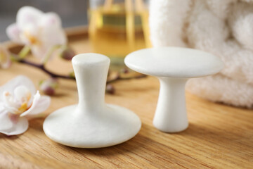 Spa stones, orchid flowers and towel on wooden tray, closeup