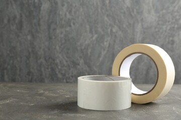 Rolls of masking tapes on grey table, space for text