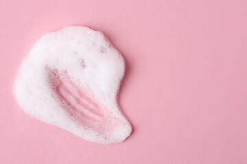Sample of fluffy foam on pink background, top view. Space for text