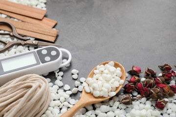 Soy wax and other supplies for making candles on grey table, closeup. Space for text