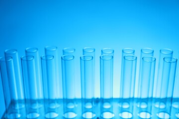 Test tubes on light blue background, closeup. Laboratory glassware