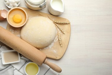 Rolling pin and different ingredients on light wooden table, flat lay. Space for text