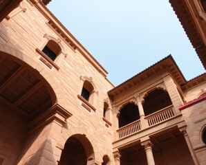 Obraz premium Majestic architecture of a historic courtyard showcasing intricate stonework under the blue sky