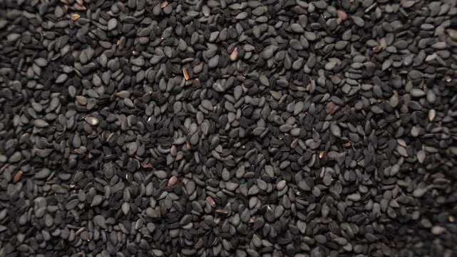 Black cumin seeds rotating in a circle, texture, background
