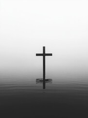 A minimalist black and white composition featuring a simple metal cross standing partially submerged in a still body of water.