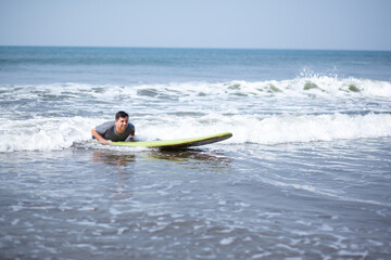A man on a vacation surfs on a board in the ocean