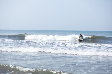 A man on a vacation surfs on a board in the ocean