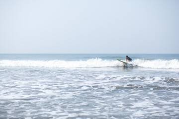 A man on a vacation surfs on a board in the ocean