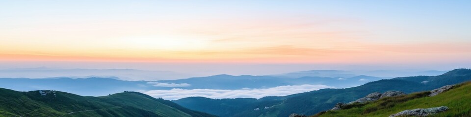 A beautiful mountain range with a cloudy sky and a sun setting in the background. The sky is a mix of orange and blue hues, creating a serene and peaceful atmosphere