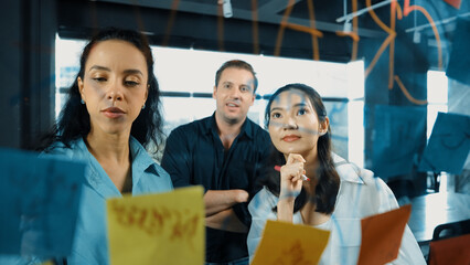 Portrait of professional diverse business team brainstorming marketing idea on colorful sticky...