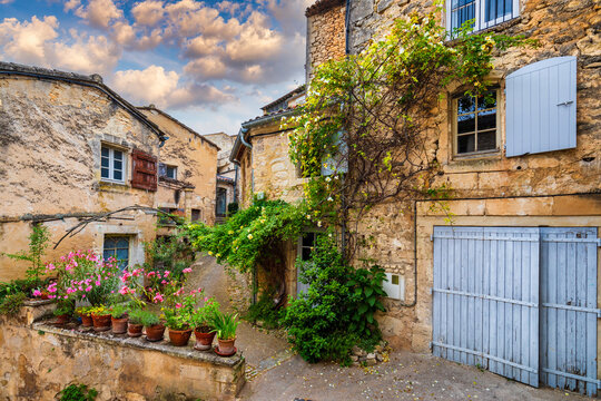 Fototapeta Charming street in quaint Menerbes village with colorful buildings and vibrant flowers. Village of Menerbes (Most Beautiful Village in France) in the Luberon mountains, France, Luberon, Vaucluse.