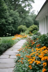 Pathway winding through a colorful flower garden beside a white house, serene scene