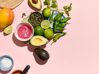 Top view of taco ingredients on a pink background