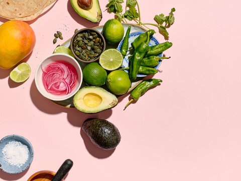 Top view of taco ingredients on a pink background