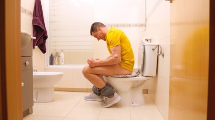 Man struggling with great constipation on toilet
