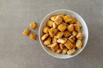 Homemade cottage cheese biscuits with caraway seeds in a white bowl on a grey surface.