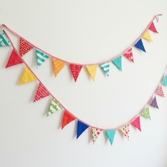 Fototapeta premium Colorful Fabric Pennant Banner Decoration - Festive bunting, cheerful party decoration, vibrant colors, playful patterns, joyful celebration. Symbolizing fun, celebration, festivity, happiness