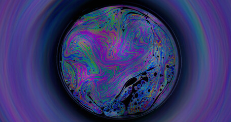 Rainbow sphere. Oil pigment. Colorful round lens on defocused black background. Abstract floating...
