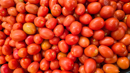 colorful arrangement of fresh, ripe red tomatoes stacked together, showcasing their natural texture and vibrancy, perfect for culinary, market, or agricultural themes.
