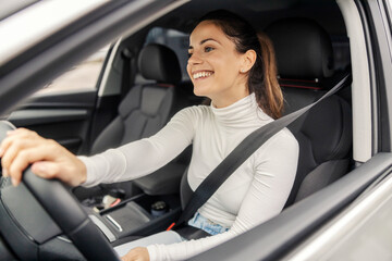 Smiling female car driver driving her auto.