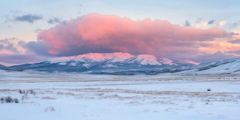 Obraz premium Beautiful snow-covered mountains, a pink sky at sunrise, and stunning clouds create a cinematic