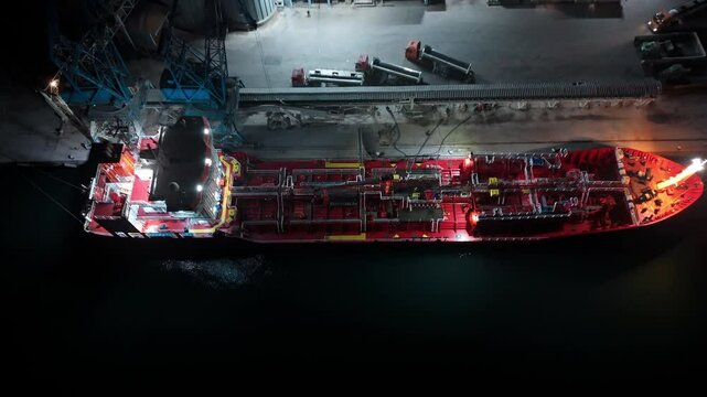 Petroleum or oil tanker ship docking at the port loading crude oil for refinery. aerial view from drone at night