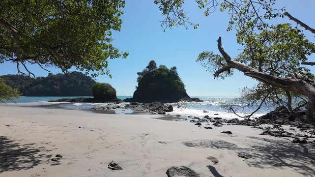 A serene tropical beach scene with gentle ocean waves lapping against the sandy shore in Costa Rica, Slow motion