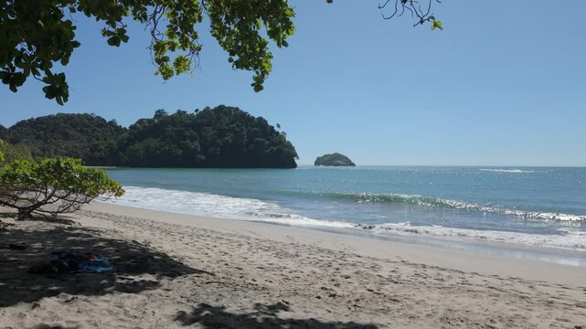 A serene tropical beach scene with gentle ocean waves lapping against the sandy shore