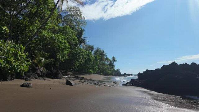 Costa Rica cove with wet shoreline beach (slow motion moving forwards)