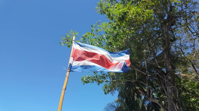 The flag of Costa Rica waving in slow motion on the beach in summer