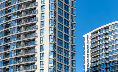 Tall modern building in urban neighborhood. New multi-story condominium under development, with...