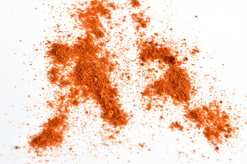 Dry and ground red pepper lies on a white background.